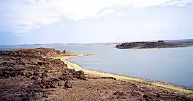 A view of a wide river separating two landmasses, on the left and right.