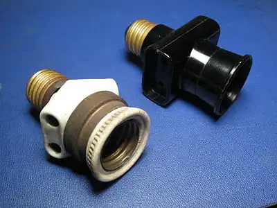 Italian bypass lampholder plugs with Edison screw mount.Left: early type (porcelain and brass, c. 1930).Right: late type (black plastic, c. 1970)