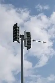 A large pole with two sets of loudspeaker horns mounted opposite each other at the top.