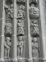 One of the carved voussure/piédroits decorating the outer rim of the entrance arch to the south porch at the église Saint-Thuriau (the lower level stones are known as piédroits and those wedge-shaped blocks higher up are voussures-voussoir in English). The scenes carved by Bastien Prigent include Adam and Eve's fall from grace, their expulsion from Eden, Adam working the land, Eve carrying Abel wrapped in swaddling clothes and Cain in a cradle, Cain and Abel making their sacrifice, Abel's murder, Noah cultivating his vine and picking the grapes and finally Noah's drunkenness and Cham's transgression. In this photograph the sculptures include Noah's ark crammed with people and animals, and Adam and Eve now aware of their nudity having tasted the forbidden fruit. They cover their private parts in shame