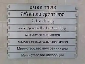 A sign at the Israeli Ministry of the Interior and Ministry of Immigrant Absorption in Haifa uses Hebrew, Arabic, English, and Russian