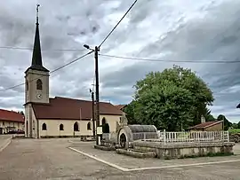 The fountain and church in Le Luhier