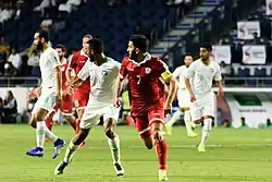 Hassan Maatouk and a Saudi player running while looking in the same direction