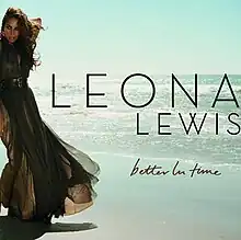 A brunette woman is standing in front of a beach. She is wearing a greenish dress and she grabs her neck with her left arm. Next to her image, the words "Leona Lewis" are written in black capital letters, and "Better in Time" in dark brown italics.