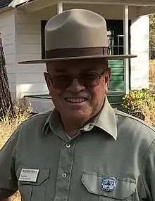 Les Joslin, in period Forest Service uniform with old forest guard badge, at the High Desert Museum's historic ranger station, 2018