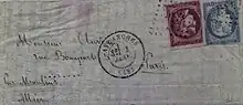 Color photograph of a letter with two stamps, one red, the other blue.