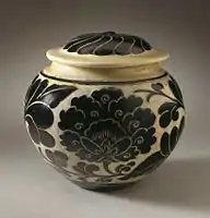 13th-century jar with lid, described as "with cream glaze and wax-resist and carved black overglaze decoration"