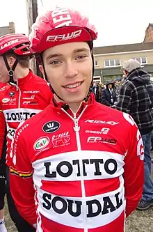 A male cyclist standing in full cycling uniform
