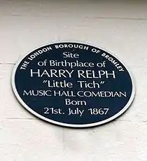 exterior of white bricked wall with blue plaque on front