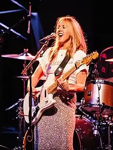 Liz Phair sings and plays guitar at a concert.