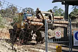 A loader with a specialized claw used to move logs at a sawmill
