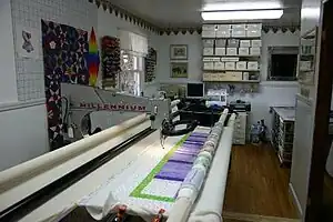 A longarm sewing machine with a quilt top placed on the frame.