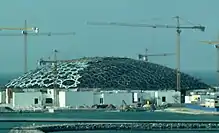 Louvre Abu Dhabi under construction in 2015, its dome built up of layers of stars made of octagons, triangles, and squares