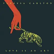 Album cover features black background with illustration of a red gloved hand pulling a tiger's tail with the words Love Is an Art below and Vanessa Carlton's name above in yellow serif font with all caps