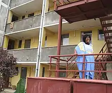 Ethiopian woman involved in PGI's pilot testing in Addis Ababa, Ethiopia, standing outside of her low income housing complex