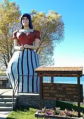 larger than life fiberglass statue of an adult woman in a striped dress