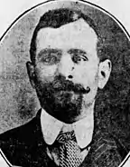 A black-and-white portrait of Luigi Galleani in a suit, facing the camera with a goatee and moustache that curls at the end