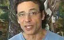 Luiz Carlos Vasconcelos wearing glasses, looking into camera while speaking