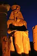 Sitting Ramesses II colossus inside Luxor Temple at night