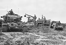 Black and white photograph of a group of military vehicles