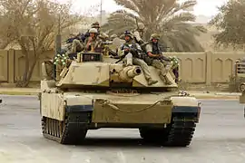 U.S. Marines ride desant aboard an M1A1 Abrams tank in Baghdad, Iraq in April 2003