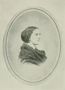 B&W oval portrait photo of a dark-haired woman wearing a dark shawl