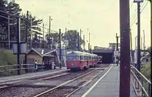 Orange-and-white streetcar on right-of-way below the level of the street