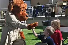 McGruff, left, high-fives two children at right