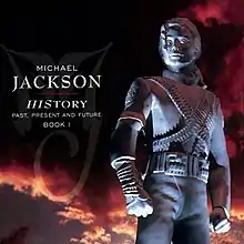 An image of a silver statue wearing a military-like outfit with its hair clipped behind its head. To the left of the statue the words "MICHAEL JACKSON" are written in white letters and underneath them is "HISTORY PAST PRESENT AND FUTURE BOOK I" written in smaller white print. Behind the statue, a sky with black and red clouds can be seen.