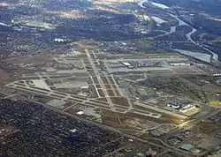 Aerial photograph of Minneapolis–St. Paul International Airport showing much of the unorganized territory of Fort Snelling. The historic fort is by the confluence of the Mississippi and Minnesota toward the upper right of the photograph, and Fort Snelling National Cemetery is at center right.