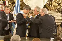 President–elect Mauricio Macri receives the presidential sash and staff from Provisional President of the Senate Federico Pinedo, instead of outgoing president Cristina Fernández de Kirchner in 2015