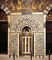 Mihrab of the mausoleum of Baybars, with marble mosaic paneling and glass mosaics above.