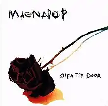 A photograph of a black rose on a stark white background with "MAGNAPOP" written at the top left and "OPEN THE DOOR" written in the bottom right in a scratchy black font.