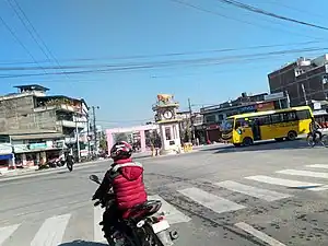 View of a crossroad (Mainchowk) of Sagarmatha Highway and Madan Bhandari Inner Terai Highway, a clock tower in center with statue of cow on its top.