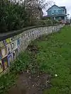 Tiles of children's artwork covering a low wall in Mallory Meadows Park