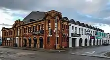 Image of the former ice skating rink in Cheetham Hill, Manchester. The building is made of red brick and the name remains embossed on the front of the building.