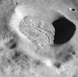 Mandelʹshtam Q from Apollo 16. The crater has a floor that is heavily lineated and grooved, but this structure is subdued rather than sharp and is contained wholly within the crater. The cracked floor is typical of a variety of craters that occur in the highlands away from the mare basins. (partial NASA caption)