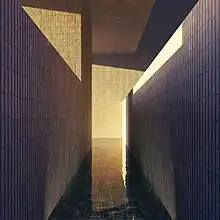 An image of a narrow corridor with a shallow pool of water in it