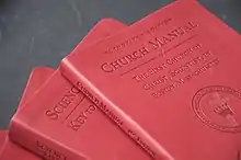 several red hard cover books in a pile