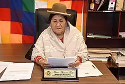 María Alanoca reads through documents while sitting at her office.