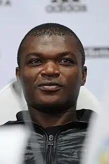 A dark-skinned man wearing a black jacket.