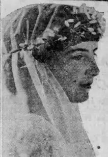 A young white woman wearing a bridal veil with a flower crown