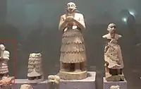Statues from Mari. The statue of Ishqi-Mari appears partially on the left: it is much smaller than many of the traditional Mari statues. Aleppo National Museum