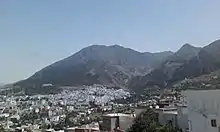 A panoramic view of Chefchaouen town situated within a mountainous area.