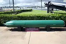 Submarine torperdo on outside display win a naval museum located neat the shore