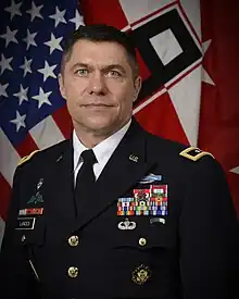 Head and shoulders photo of Major General Mark H. Landes, dress uniform, head and shoulders, in front of United States and First Army flags