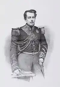 Lithograph of a drawing featuring a three-quarters length portrait of a middle-aged man with moustache wearing a military tunic with embroidered cuffs and decorated with epaulettes, lanyards, a sash of office and several medals and orders at his neck, and holding a feathered bicorne hat in his right hand