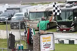The flagman displays the checkered flag in 2018