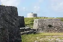 The evolution of coastal fortification design, between the 1790s and 1822, can be discerned between Ferry Island Fort (in the foreground), with multiple guns arrayed to cover the water westward, and the Martello tower in the background, which used a single gun with 360° traverse to cover the area.