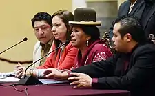 Martha Yujra speaks into a microphone during a press conference.